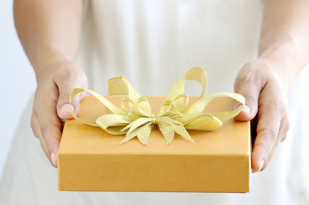 Woman holding a gold gift box - Photo, Image