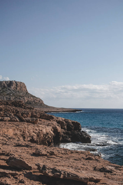 Όμορφη παραλία με λιμνοθάλασσα και κύματα μπροστά από το βουνό Cape Greco στην Αγία Νάπα, Κύπρος.  - Φωτογραφία, εικόνα
