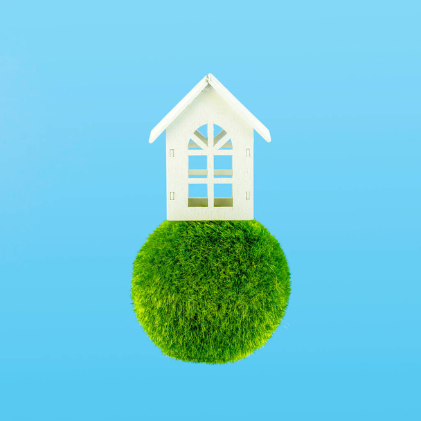 Wooden white house on a sphere green grass with sky blue background. Eco house concept - Φωτογραφία, εικόνα