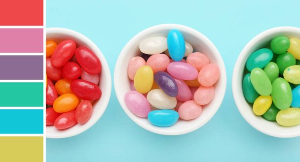 Sweet candies in bowls on light blue background. Different color patterns - Photo, image