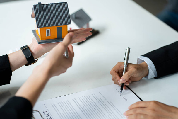 Real estate agents advise clients to enter into contracts to purchase houses and land after the contract is approved. Offer a mortgage loan with home insurance ideas. - Photo, image