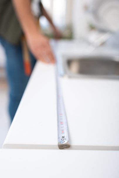 Обрізаний вид розмитого майстра вимірювання кухонної стільниці
  - Фото, зображення