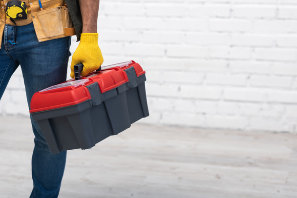 Partial view of repairman holding toolbox at home  - Photo, Image