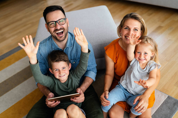 Happy young family having fun time at home. Parents with children using digital device. Education parenting happiness concept. - Valokuva, kuva