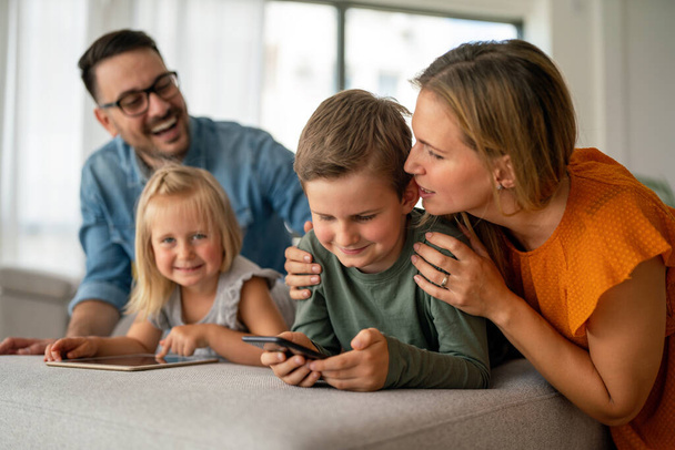 Happy young family having fun time at home. Parents with children using digital device. Education parenting happinness concept. - Valokuva, kuva