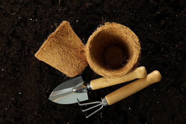 Gardening tools on soil background, top view - Фото, изображение