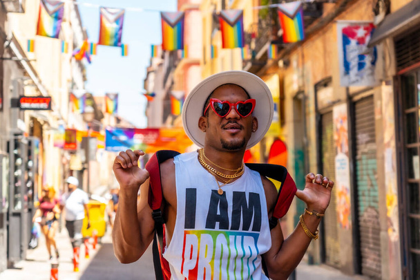 A gay black man at the pride party visiting the decoration of the city, LGBT flag - 写真・画像