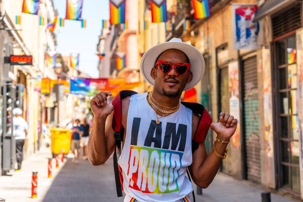 A gay black man at the pride party visiting the decoration of the city, LGBT flag - Фото, изображение