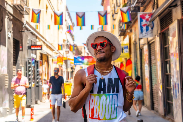 A gay black ethnicity man enjoying and smiling at the pride party, LGBT flag - 写真・画像