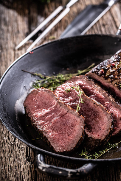 Grilled beef steak in a pan with herbs. - 写真・画像