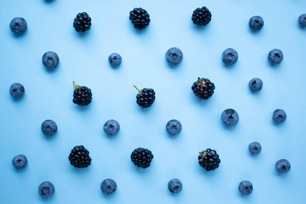 blueberry and blackberry on blue background - Photo, Image