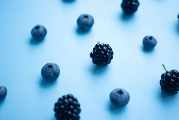 blueberry and blackberry on blue background - Fotoğraf, Görsel