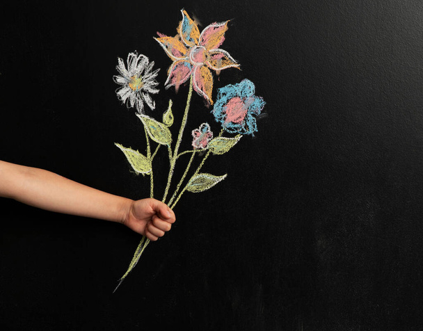 Image of little boy's hand holding a drawn bouquet of flowers on - Φωτογραφία, εικόνα