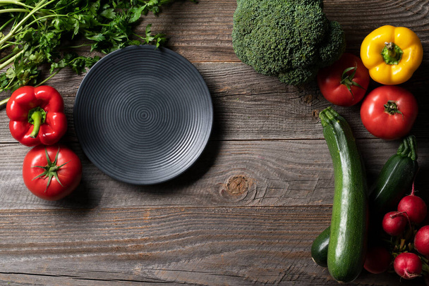 Very fresh vegetables exposed on the cintage wooden table with decorative platter. Meal preparing - Foto, Imagem