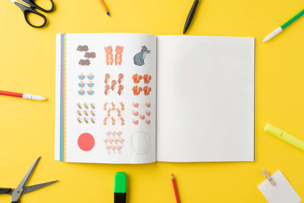 Top view of pre school text book surrounded by school supplies. Educational concept. - Photo, Image