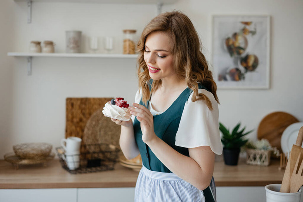 Housewife holding a cake in her hands while standing in the kitchen. High quality photo - Foto, afbeelding
