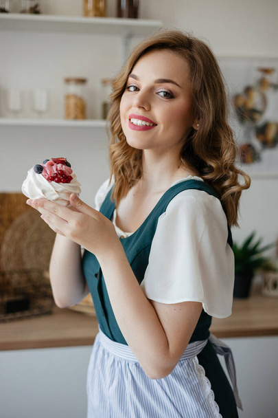Housewife holding a cake in her hands while standing in the kitchen. High quality photo - Foto, Imagem