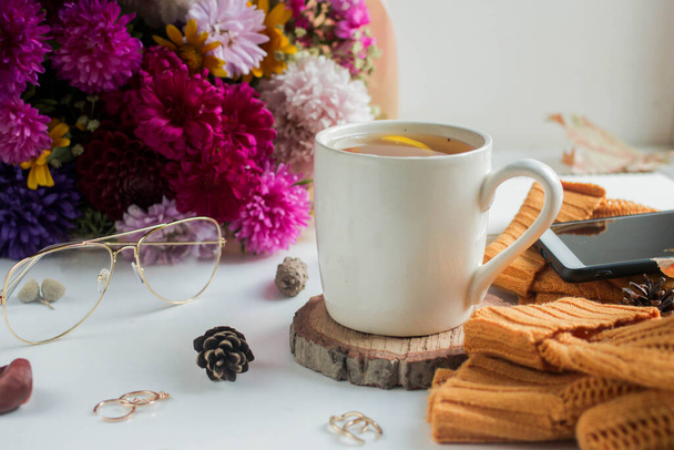 Чашку чая с лимоном. цветы и желтый свитер - Фото, изображение