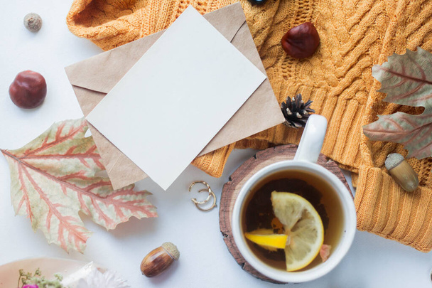fall mockup card with autumn leaves invitation card with environment and details Mockup with postcard and sweater with wood elemets on white background. - Foto, imagen