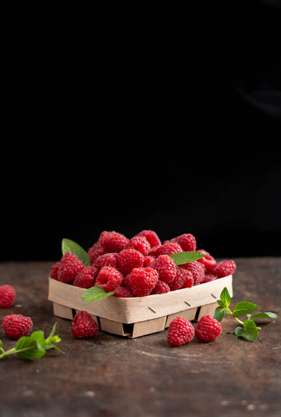 fresh raspberry in basket on dark wooden background - Foto, Imagen