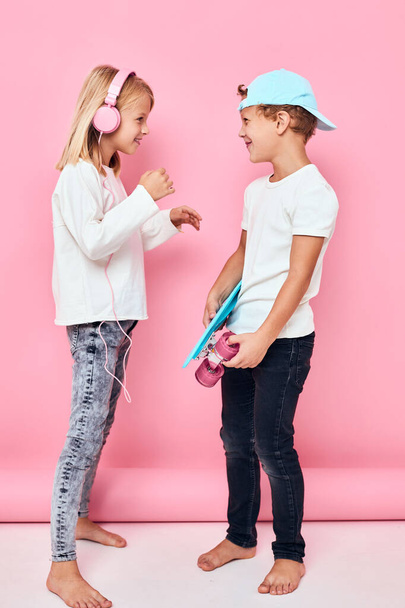 мальчик в кепке и девушка, улыбающаяся и слушающая музыку в наушниках, детство. Высокое качество фото - Фото, изображение
