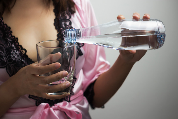 Naisen kädet kaatamalla vettä lasiin
 - Valokuva, kuva