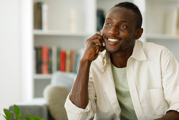 Smiling young African American making a call, talking on the phone. High quality photo - Φωτογραφία, εικόνα