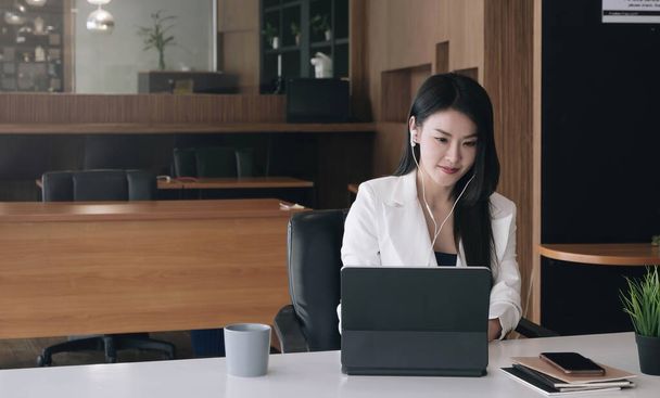 charmante asiatische Geschäftsfrau sitzt am Laptop im Büro - Foto, Bild