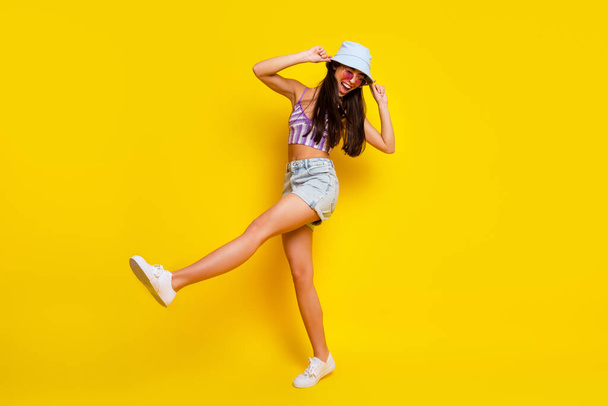 Full body image of young energetic slender tanned girl dancing on tropical island vacation isolated on yellow color background. - Fotografie, Obrázek