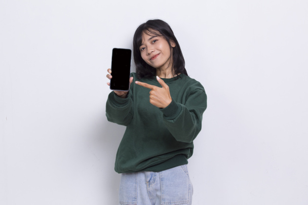 молода красива азіатська мила жінка демонструє мобільний телефон ізольовано на білому тлі
 - Фото, зображення