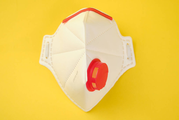 FFP3 class filtering mask respirator isolated on yellow background. - Fotó, kép