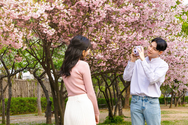 Korean Asian couple enjoying spring date_taking a photo - Foto, Imagen