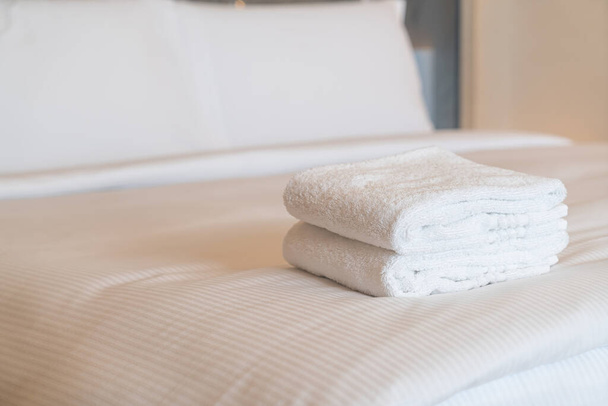 white shower towel stack on bed - Foto, afbeelding
