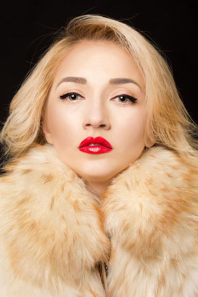 Portrait of a beatyful blond woman in fur clothes. Red lip stik - Photo, Image