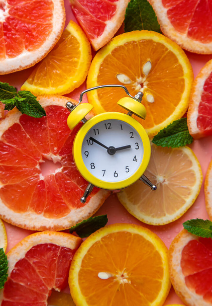 Clock and citruses summer time concept. Selective focus. Food. - Photo, Image