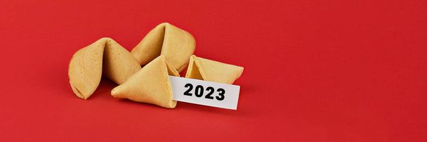 2023 Chinese fortune cookies. Cookies with white blank and 2023 text inside for prediction words. Isolated on red background - Foto, Imagen