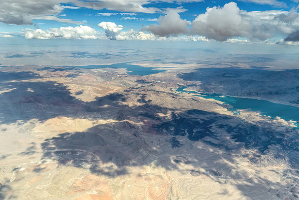 An aerial view shows a beautiful mountain landscape that rises from the desert surrounding Las Vegas, Nevada with landforms and Lake Mead - Φωτογραφία, εικόνα