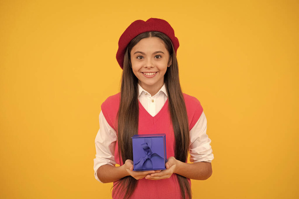 tween and youth. purchase a gift. good offer. happy french teen girl hold present box. childhood happiness. boxing day. cheerful kid in beret. smiling child has birthday. teenage beauty go shopping. - Photo, Image