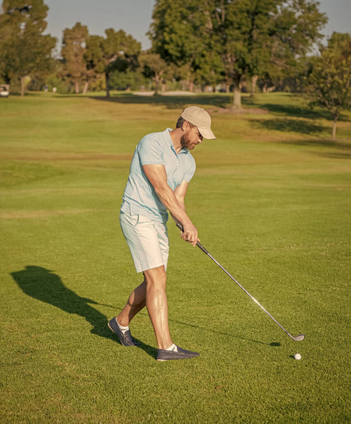 Άντρας παίκτης του γκολφ σε επαγγελματικό γήπεδο γκολφ. πορτρέτο του παίκτη του γκολφ στο καπέλο με μπαστούνι του γκολφ. τρόπο ζωής των ανθρώπων. άνθρωπος που παίζει παιχνίδι στο πράσινο γρασίδι έξω. καλοκαιρινή δραστηριότητα. επαγγελματικό αθλητισμό εξωτερική. - Φωτογραφία, εικόνα