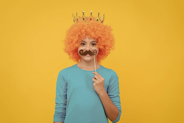 party accessories. imagine herself princess. funny child with party moustache. selfish teen girl in tiara. pageant. april fools day. just having fun. fancy look. egocentric kid in clown wig and crown. - Photo, Image
