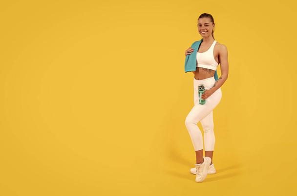 sport femme avec bouteille d'eau sur fond jaune. espace de copie. - Photo, image