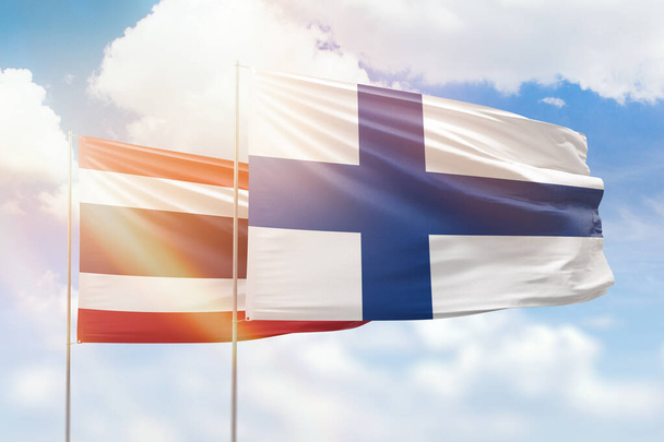 Sunny blue sky and flags of finland and thailand - Photo, Image