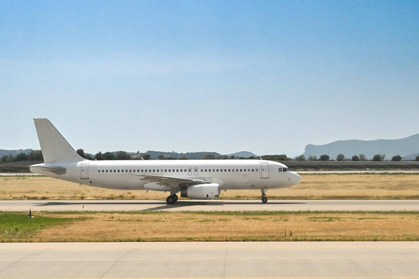 Unmarked passenger jet taxiing for take-off at an airport. No people.  - Foto, Imagem