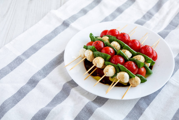 Homemade caprese skewer appetizer on a plate, top view. Flat lay, overhead, from above. Copy space. - Foto, Imagen