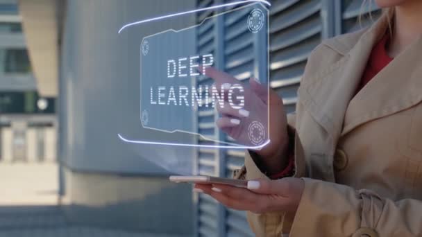 Unrecognizable businesswoman interacts HUD hologram with text Deep learning. Woman in the coat uses the technology of the future mobile screen on the background of the city - Materiał filmowy, wideo