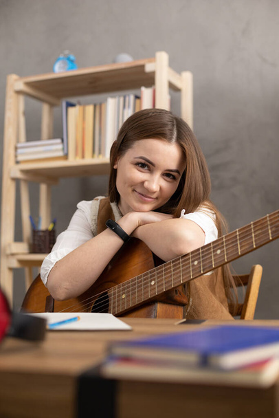 Girl holding acoustic guitar. Musician woman playing in studio and classic guitar - Photo, Image