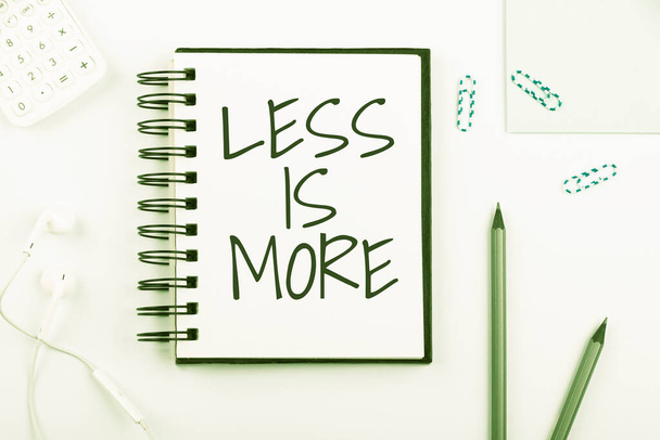 Conceptual caption Less Is More, Business showcase Minimalist approach to artistic matter is more effective Notebook With New Message On Desk With Pens, Headphones And Paperclips. - Photo, Image