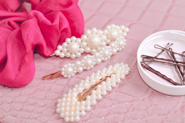Set of pearl hairpins and elastic bands on pink background . High quality photo - Valokuva, kuva