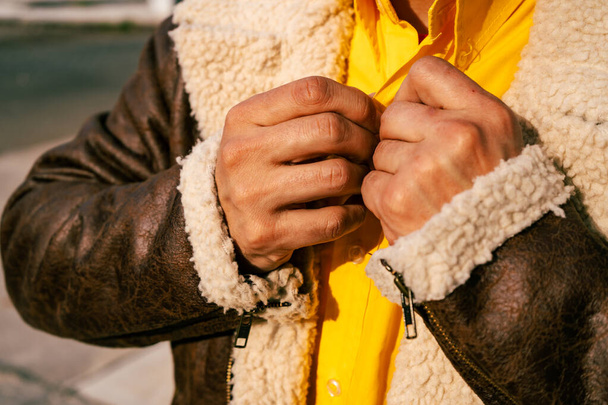 Close up of a Man's hands fastening a button on a yellow shirt. - Foto, Imagem