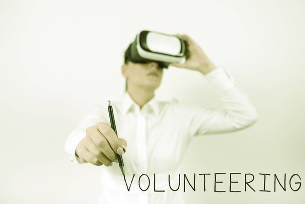 Inspiration showing sign Volunteering, Internet Concept Provide services for no financial gain Willingly Oblige Woman Wearing Vr Glasses And Pointing On Recent Updates With Pen. - Foto, Imagen